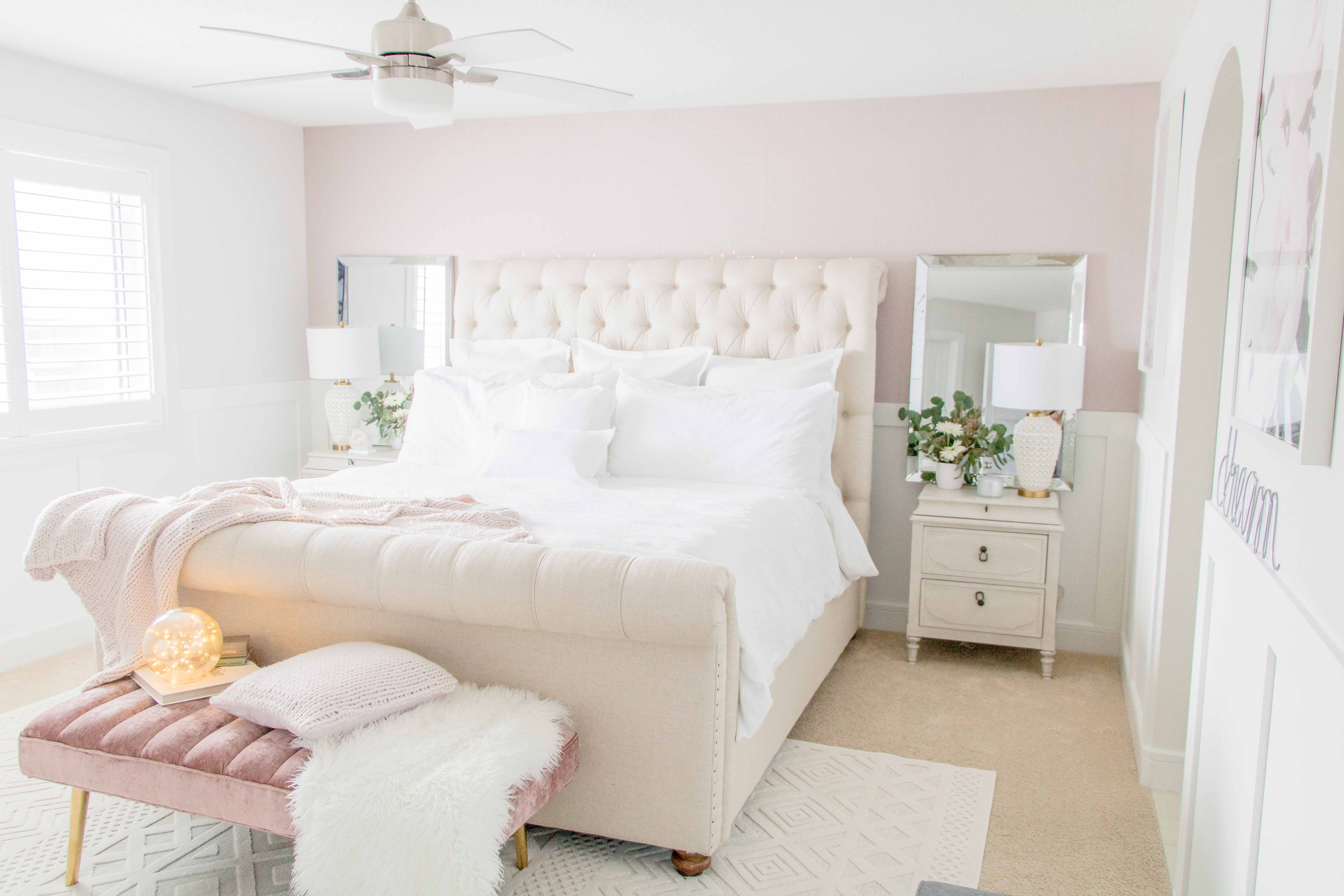 Bedroom with pink walls and white linen on the bed