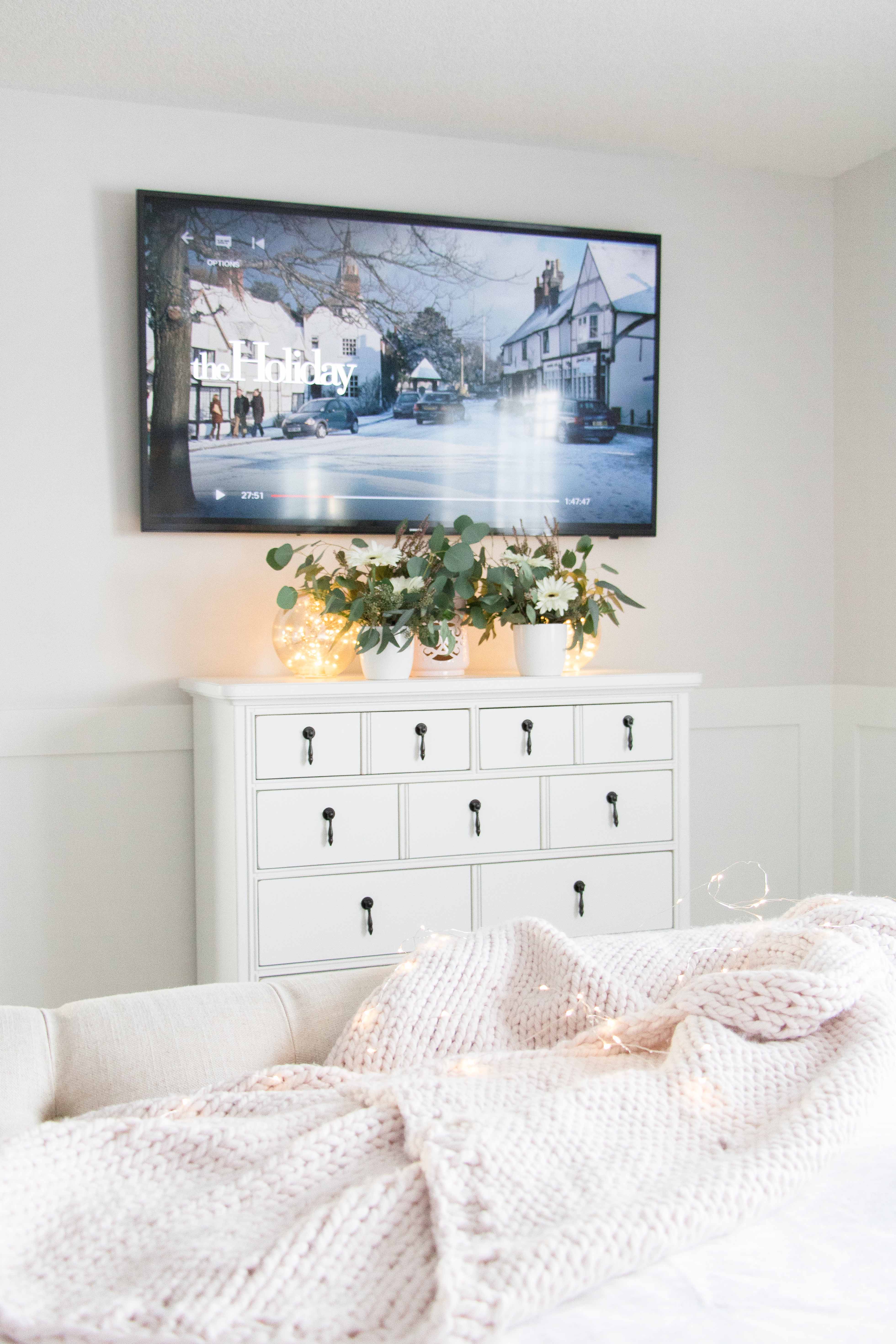 White bedroom dresser with TV above it